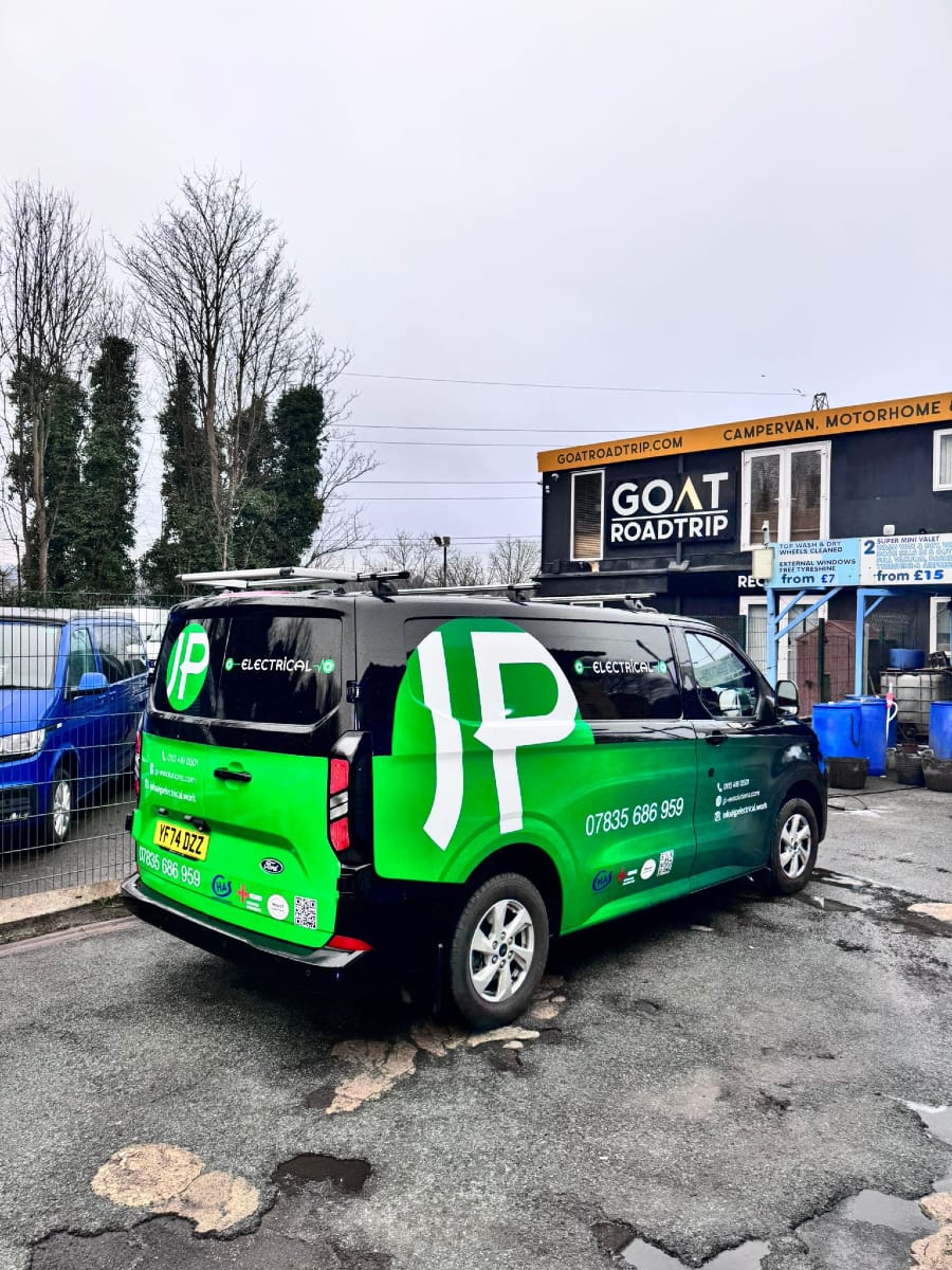 Green JP Electrical & EV Solutions van parked outside Goat Roadtrip campervan centre